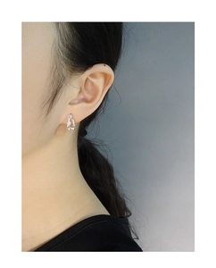 Close-up of minimalist S925 sterling silver hoop earrings with crossover lines on model