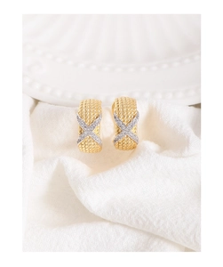 Macro shot of gold twist rope earrings with silver X-shaped zircon pavé details