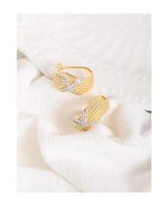 Detail of gold twisted rope earrings with silver X cross set with sparkling zircon