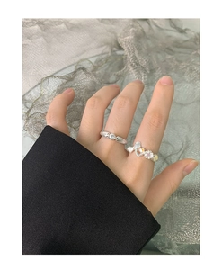 Close-up of S925 silver bow and heart moonstone rings worn on hand for display