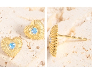 Détail de boucles d'oreilles cœur en argent S925 avec zircon bleu et fini doré