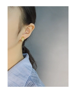 Close-up of S925 sterling silver twist earrings with zircon accents worn by a model