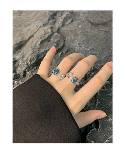 Makroaufnahme von S925 Silberring-Set mit unregelmäßigen blauen Opalsteinen auf Felsen