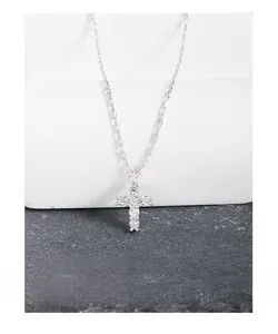 Macro shot of S925 sterling silver cross pendant featuring sparkling zircon crystals