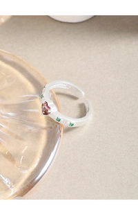 Detail of S925 silver ring featuring pink heart zircon and green stones with textured band