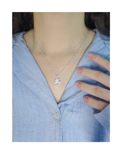 Macro detail of S925 sterling silver necklace with irregular molten texture round pendant