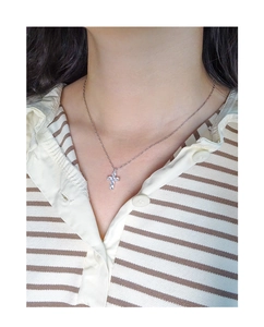 Close-up of minimalist S925 silver cross pendant necklace with zircon stones on model