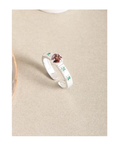 Detail of S925 sterling silver ring featuring a heart zircon and green side stones