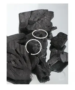 Macro shot of silver S925 twist braided open ring set on artistic black charcoal background