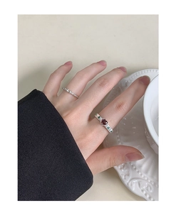 Close-up of S925 silver ring featuring red heart zircon and green side stones