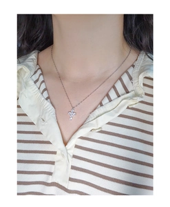 Close-up of S925 silver cross necklace with zircons worn on a model's neck