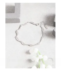 Macro view of minimalist S925 sterling silver wave link bracelet with lobster clasp