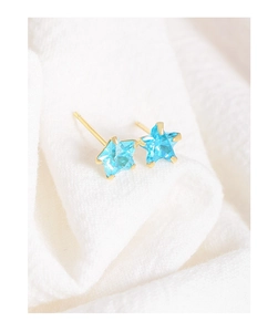 Macro shot of S925 silver star earrings with brilliant light blue zircon in gold finish