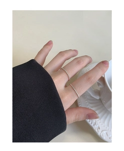 Detail of two stacked silver minimalist twisted rope rings on fingers against a minimalist background
