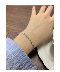 Close-up of S925 sterling silver wave chain bracelet worn on a female wrist