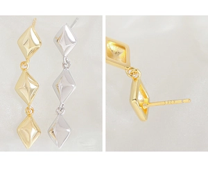 Macro shot showing S925 silver hallmarks on gold and silver geometric dangle earrings
