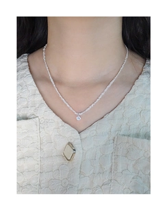 Détail d'un collier multicouche en argent avec un pendentif en zircon étincelant