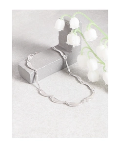 Detailed shot of S925 sterling silver ocean wave bracelet links on stone display