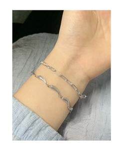 Detail view of S925 sterling silver layered wave bracelet and paperclip chain for women