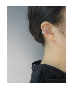 Detailed close-up of a silver S925 ear cuff with irregular lava texture worn on the ear