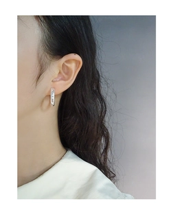 Gros plan d'une boucle d'oreille créole minimaliste en argent S925 sur l'oreille d'un mannequin