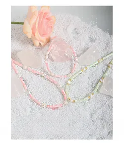 Detailed shot of Baroque pearl bracelet with pink and green beads on white stones