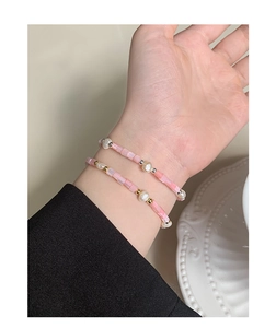 Close-up of double-layer pink beaded bracelet with baroque pearls on model wrist