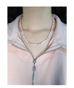 Detail of beaded necklace with pink faceted beads and pearls worn with pink top