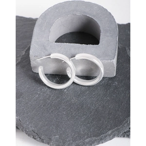 Boucles d'oreilles créoles minimalistes en argent S925 sur fond de pierre gris industriel