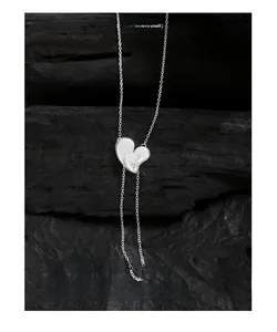 Detailed macro shot of an S925 sterling silver heart pendant with long tassels