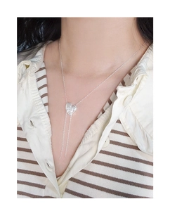 Detailed view of S925 silver heart tassel necklace on model with knit sweater