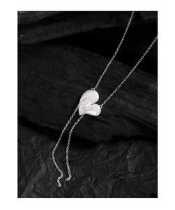 Macro shot of S925 sterling silver heart pendant with polished finish on black texture