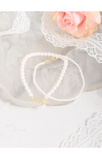 Close-up of S925 silver pearl bracelets with gold clasps on a lace background
