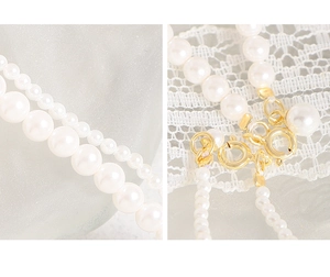 Detailed macro view of S925 sterling silver pearl necklace with gold spring ring clasp