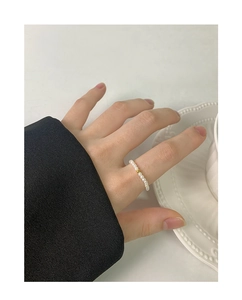 Detail of 2mm pearl beaded ring with a central gold bead worn on finger
