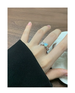 Detail of S925 silver lava texture heart ring with iridescent synthetic opal on a finger