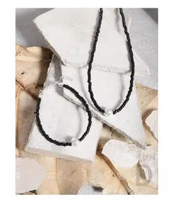Detail of S925 sterling silver black agate beaded necklace on industrial concrete blocks