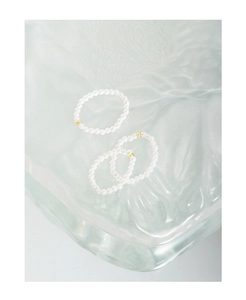 Detailed view of three-piece 2mm pearl bead ring set with golden accent beads