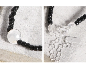 Macro detail of S925 silver lobster clasp and extender chain on black agate bead necklace