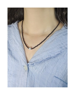 Close-up of a beaded black agate choker necklace with a silver bead on a model