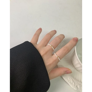 Elegant S925 silver ring with 2mm white pearls and a gold bead on a woman hand