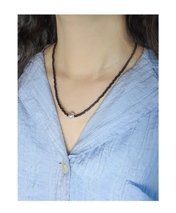 Detail of S925 silver bead on minimalist black onyx choker necklace worn on neck