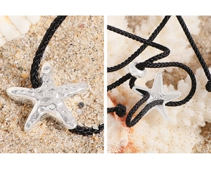 Macro shot of silver starfish pendant showing S925 hallmark on black cord necklace