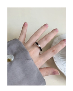Dettaglio dell'anello elastico in argento S925 con perle di agata nera lucide sul dito