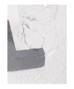Gros plan sur une bague Mobius en argent S925 avec motifs d'étoiles gravés sur papier blanc