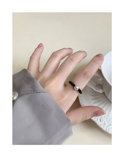 Dettaglio dell'anello elastico in agata nera e perla in argento S925 al dito