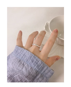 Vue rapprochée d'une bague Mobius en argent S925 avec texture martelée sur un doigt