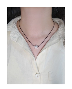 Detailed shot of S925 silver starfish pendant with hammered texture on black cord necklace