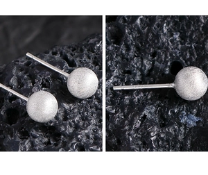 Macro view of S925 sterling silver ball stud earrings with matte brushed finish detail
