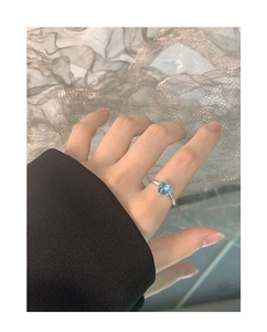Close-up of S925 sterling silver ring featuring a heart-shaped blue gemstone in claw setting